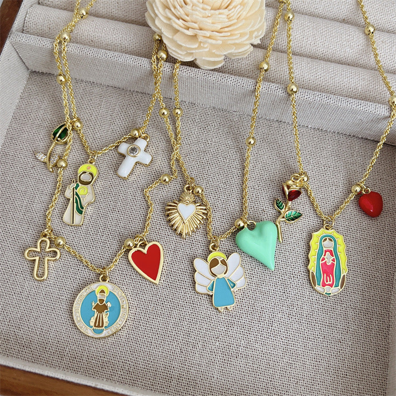 Trendy gold necklace with angel, green heart and sacred heart