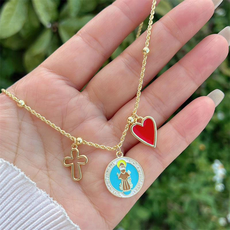 Trendy gold necklace with Saint Francis, cross and red heart