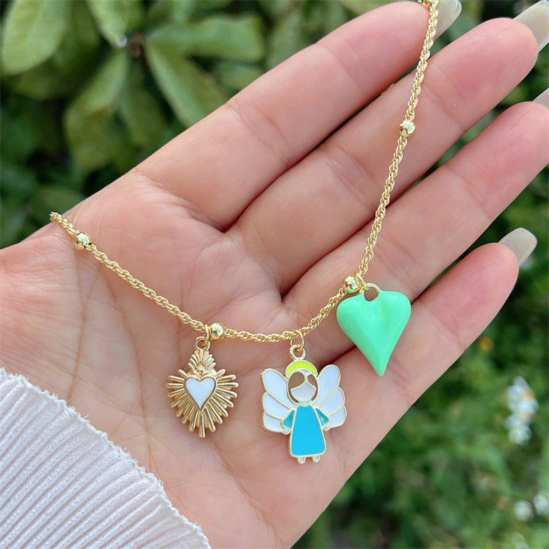Trendy gold necklace with angel, green heart and sacred heart