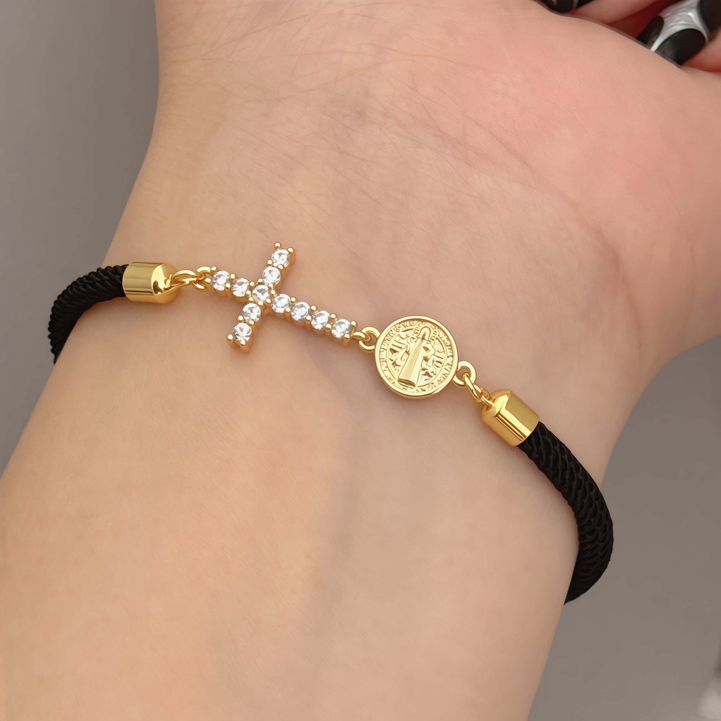 Black bracelet with a zirconia cross and a religious charm of Saint Benedict the Abbot