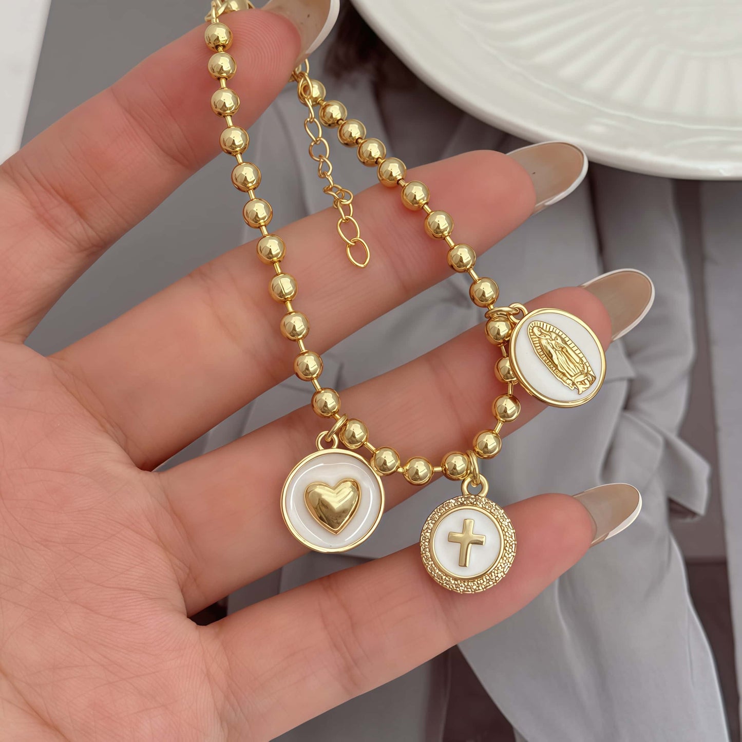 Gold religious bracelet with white religious charms