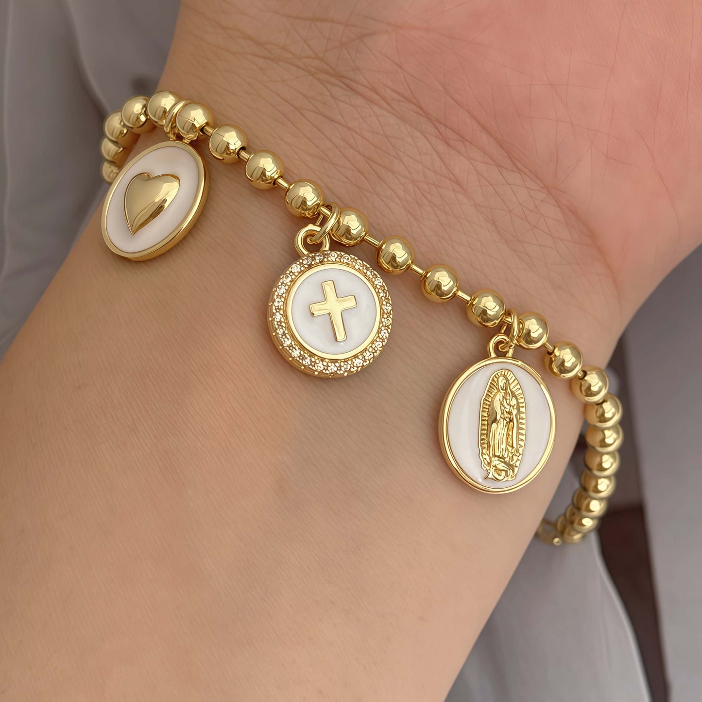 Gold religious bracelet with white religious charms