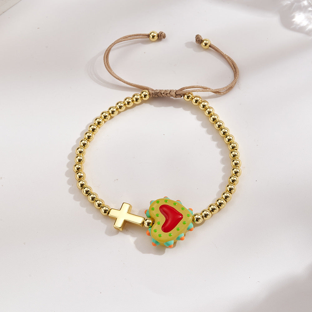 Adjustable bracelet with gold beads, cross and heart, enameled green with red